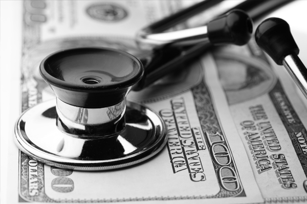 Saúde financeira - instrumento médico sobre uma nota de 100 dólares 