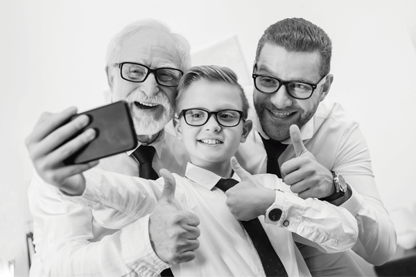 Três homens vestidos de forma semelhante. Um idoso, um adulto e uma criança. Eles representam 3 gerações de homens de negócio 
